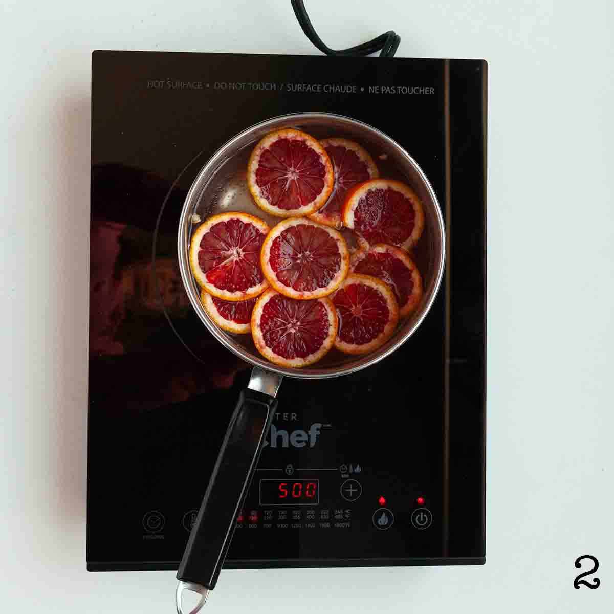 Blood orange slices simmering in syrup.