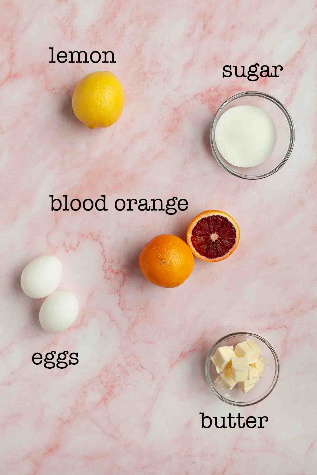 Ingredients for blood orange curd--lemon, sugar, blood orange, eggs, and butter.