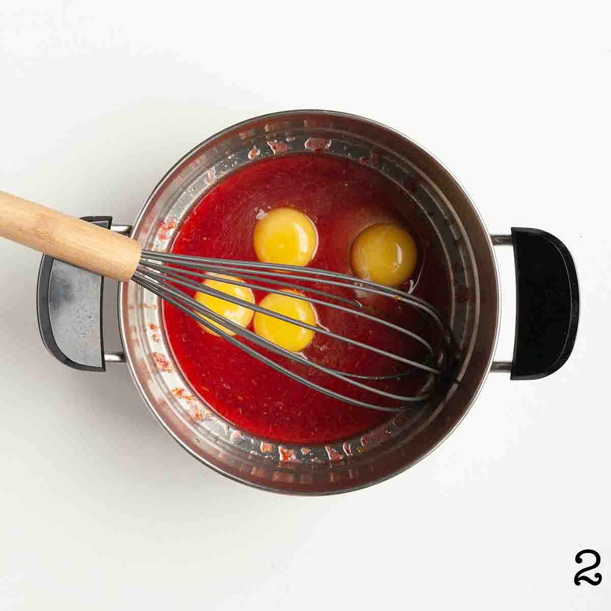 Eggs in a blood orange syrup in a double boiler.