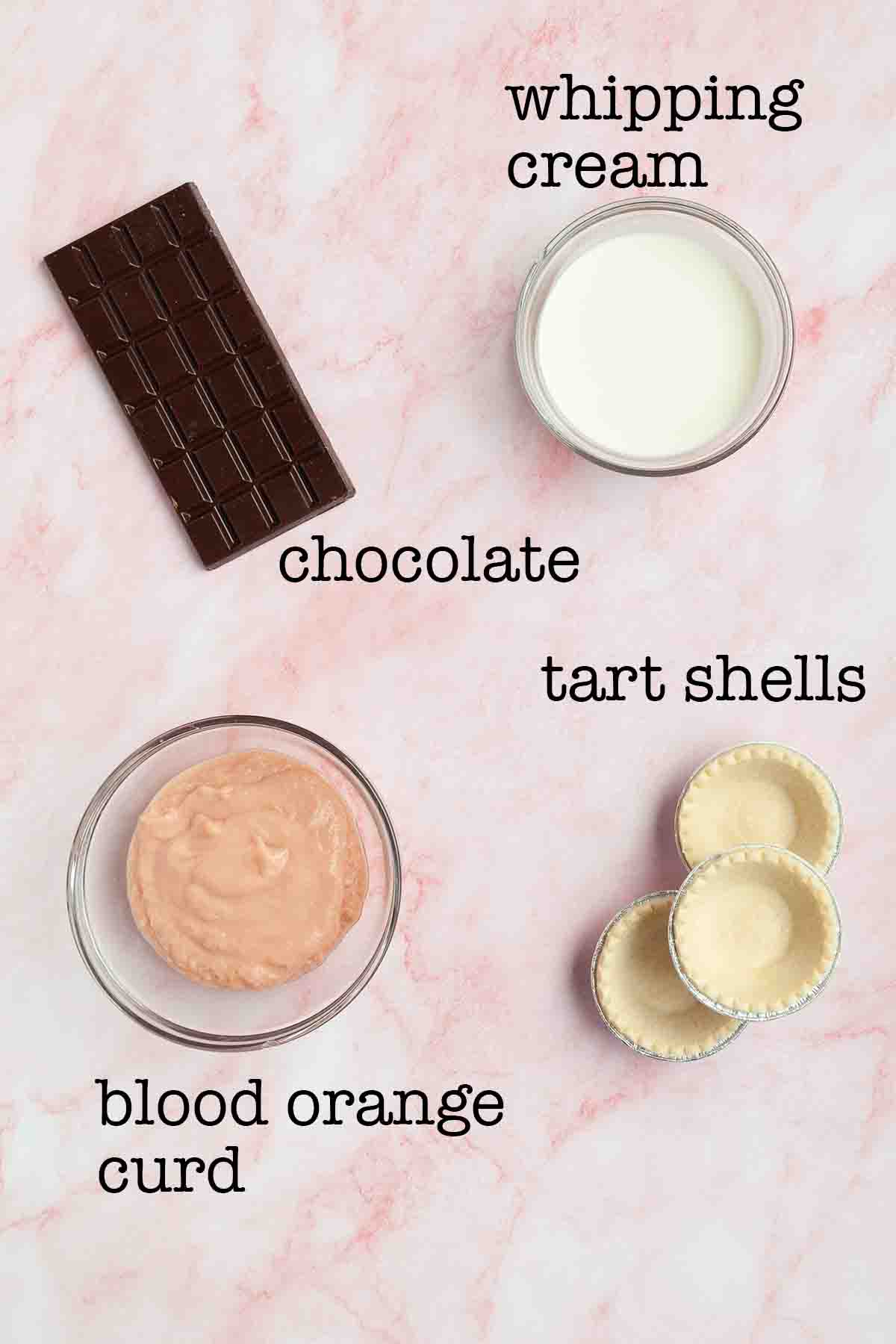 Ingredients for blood orange tartlets--chocolate, whipping cream, tart shells, and blood orange curd.