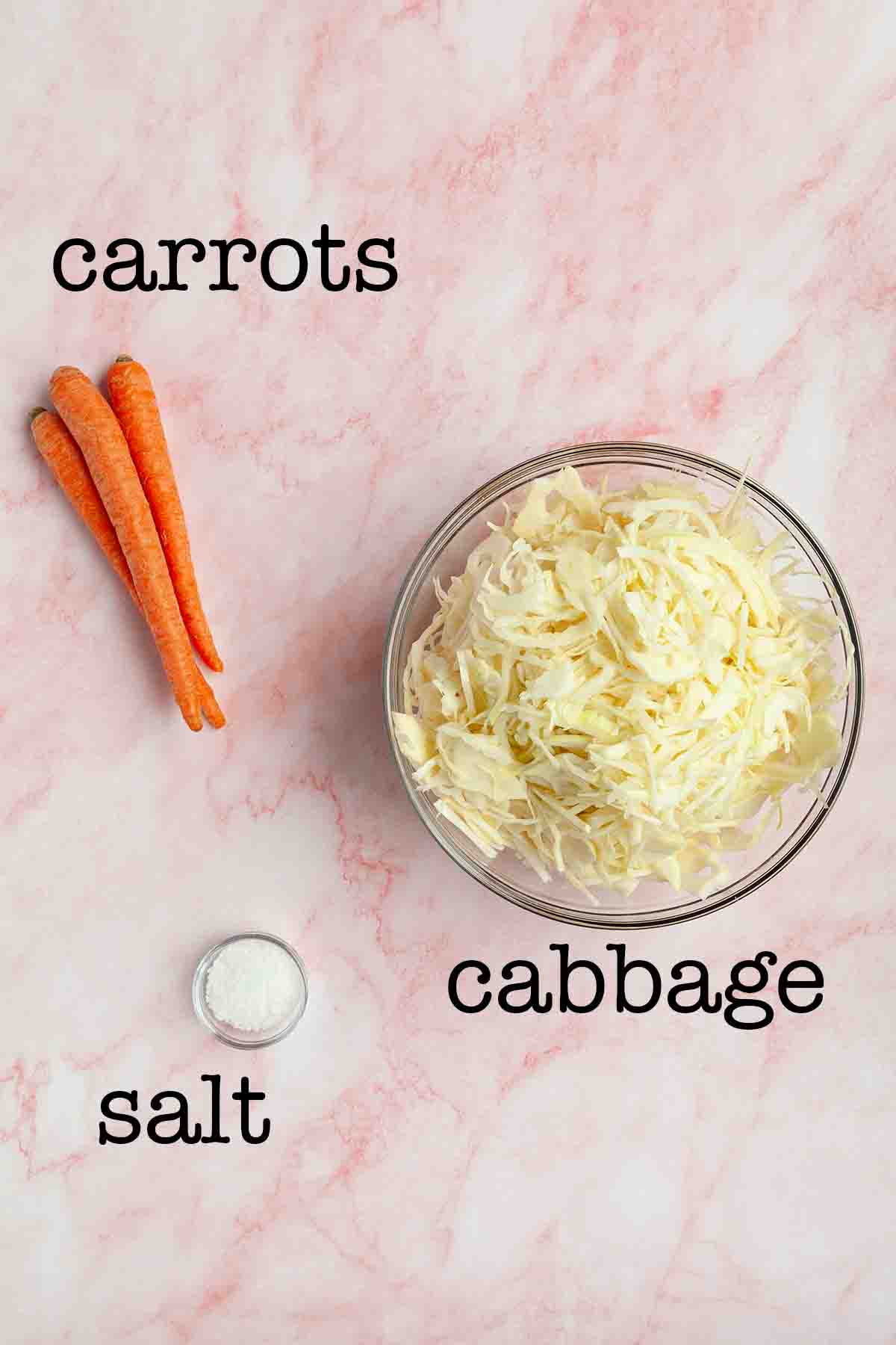 Ingredients for sauerkraut with carrots--carrots, cabbage, and salt.