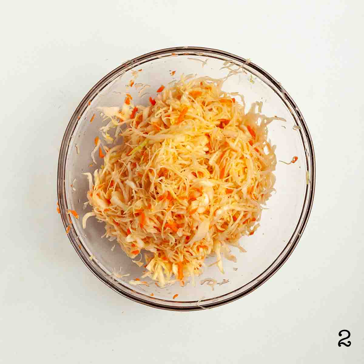 Shredded cabbage and carrots in a bowl.