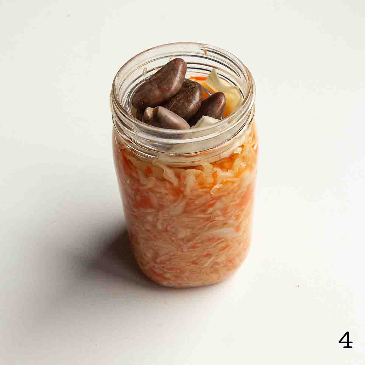 A jar of sauerkraut with a rock weight on top.
