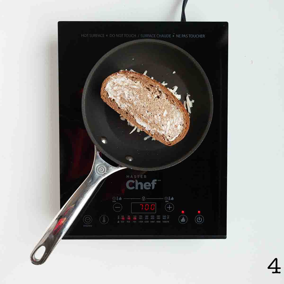 A grilled cheese sandwich on rye bread in a skillet.