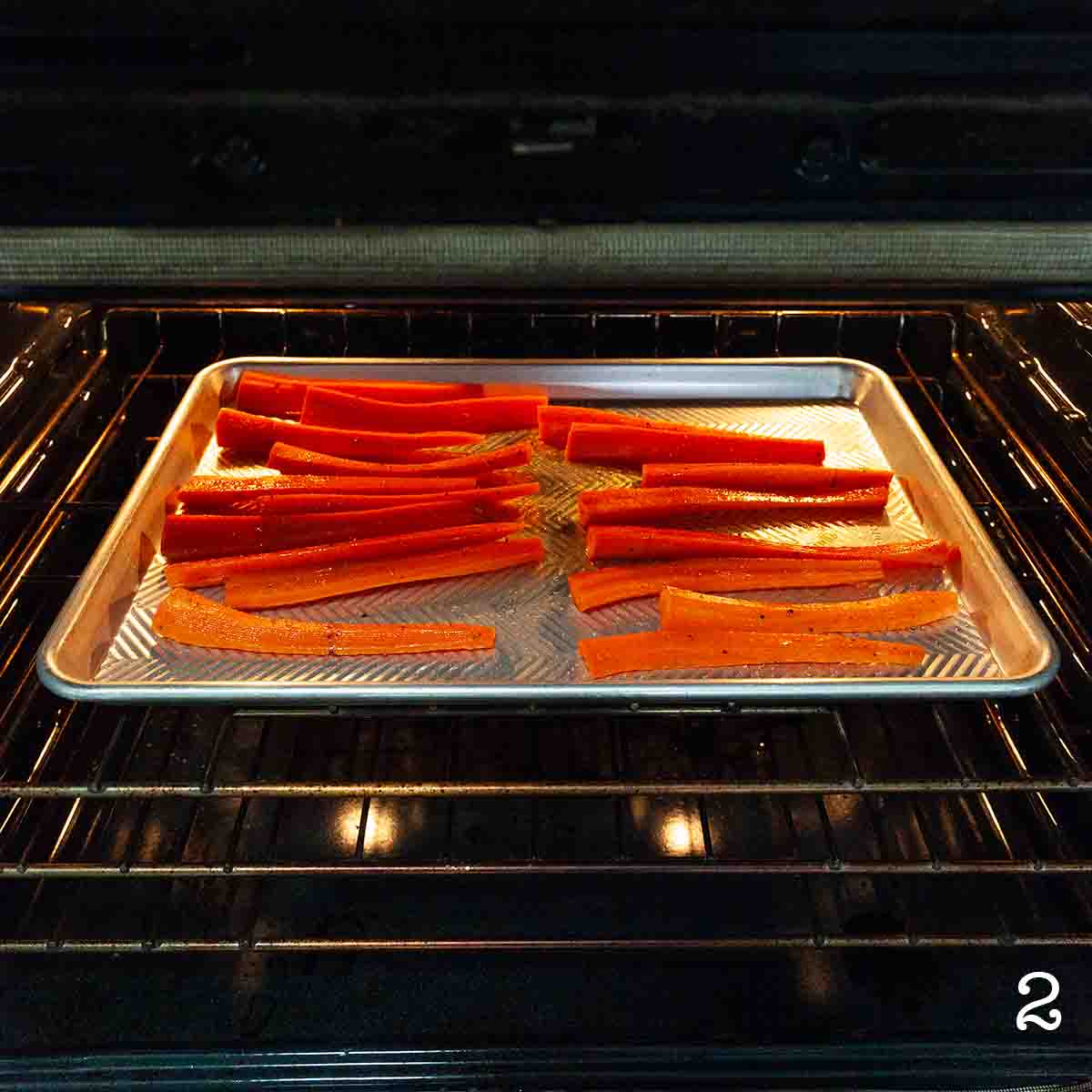 Carrots on a baking sheet roasting in the oven.
