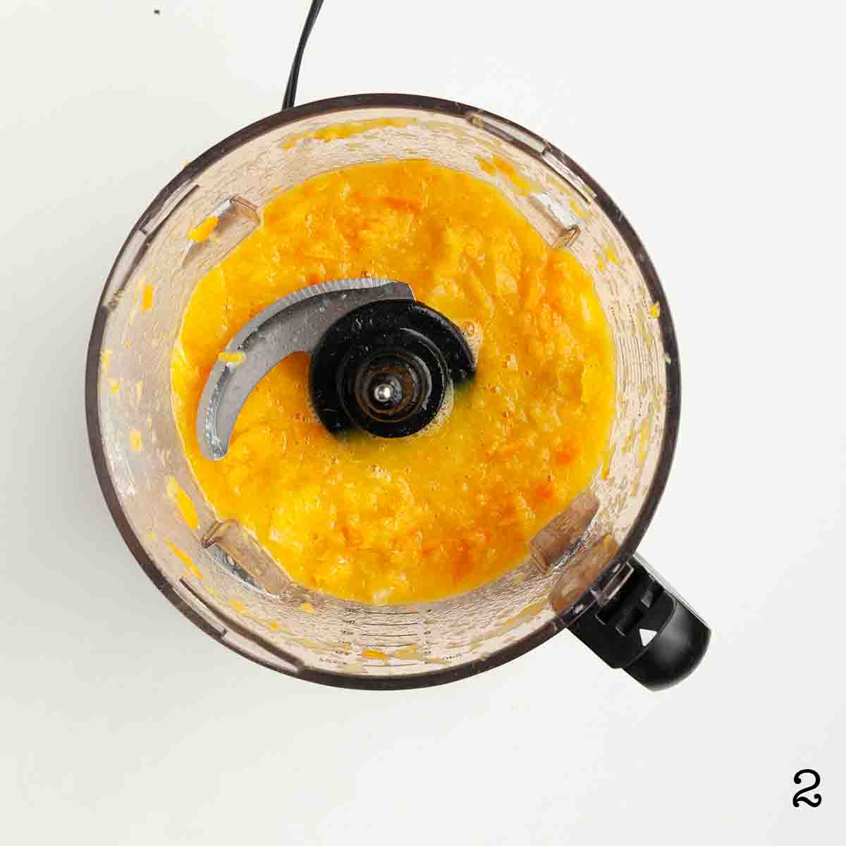 A food processor containing pureed oranges and lemons.