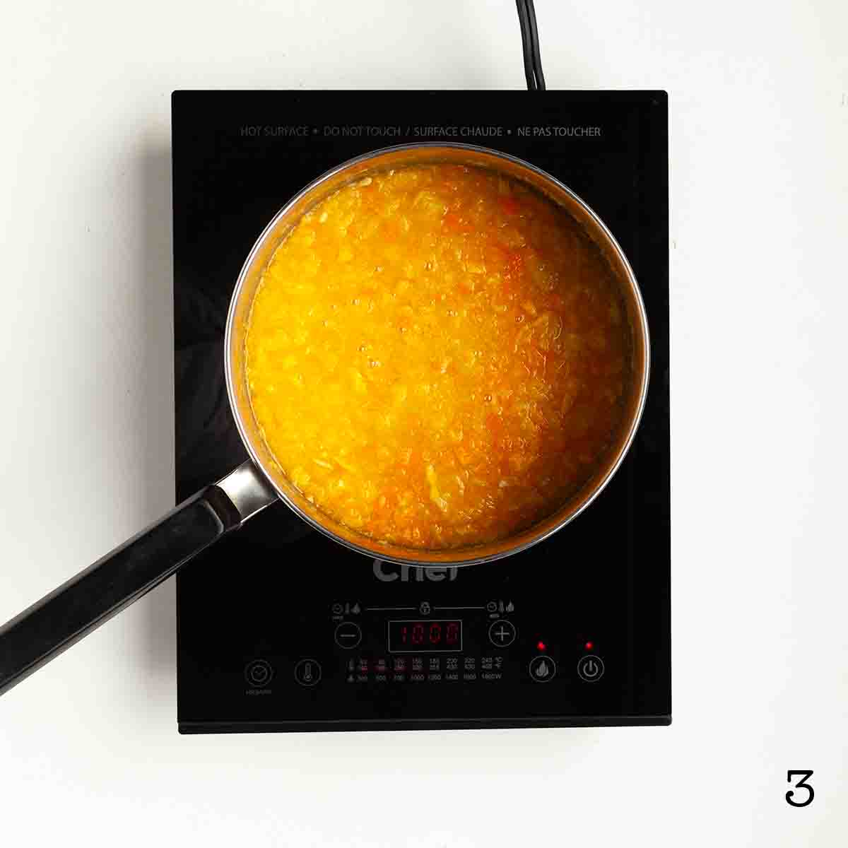 A marmalade mixture in a pot on a burner.