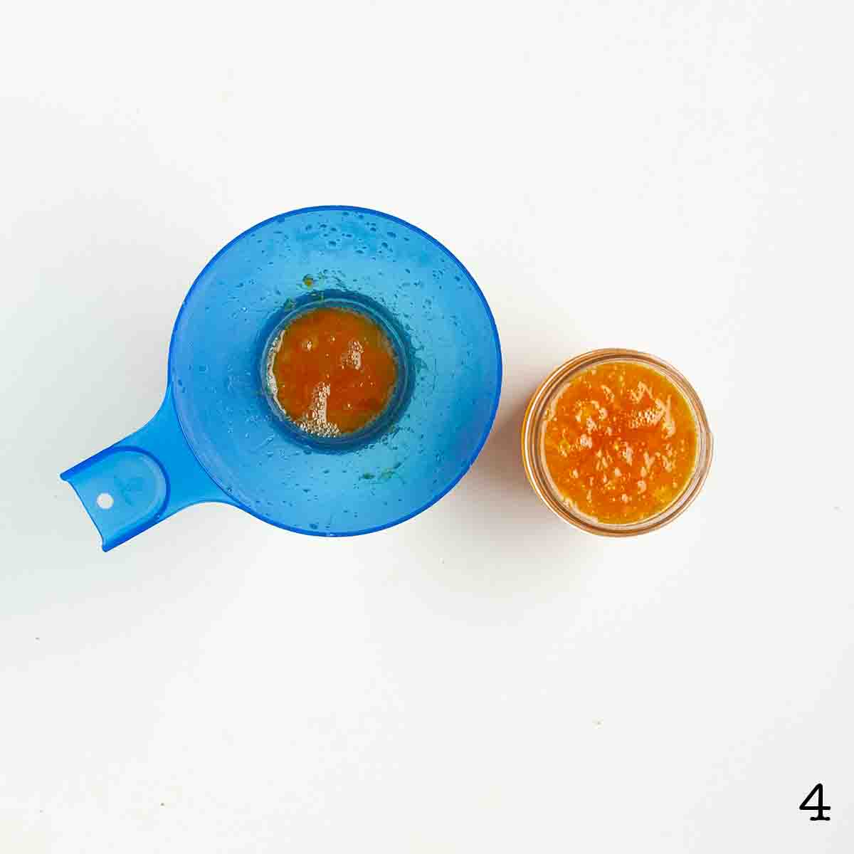 Marmalade being poured into small glass jars.