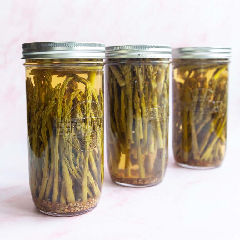 Three jars of pickled asparagus.