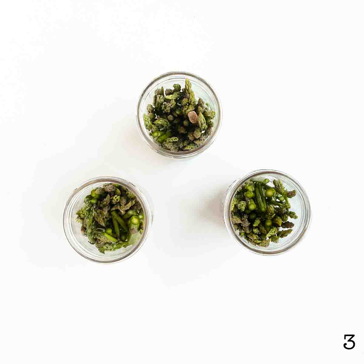 Three jars filled with asparagus.