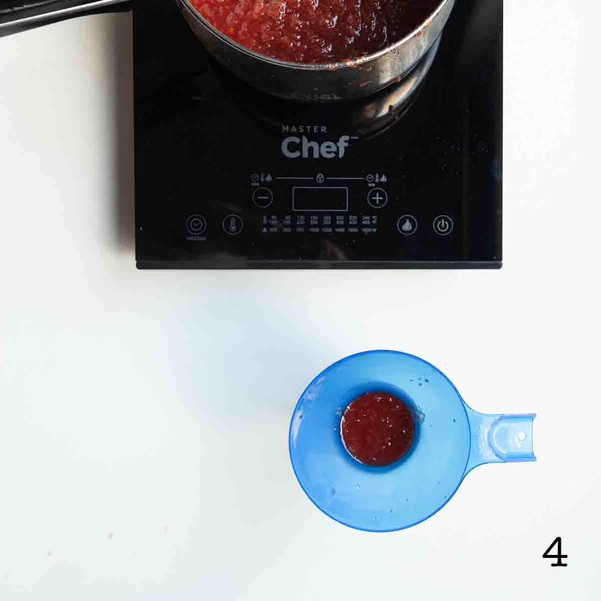 Jam being added to a jar through a funnel.