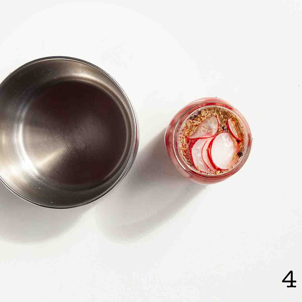A jar of sliced radish with pickling liquid poured over the top.