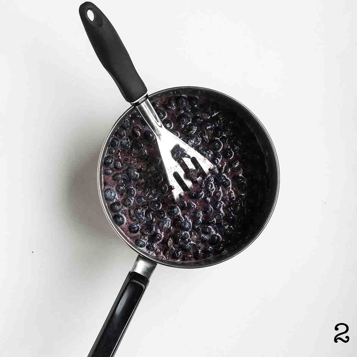 Mashed blueberries in a pot.