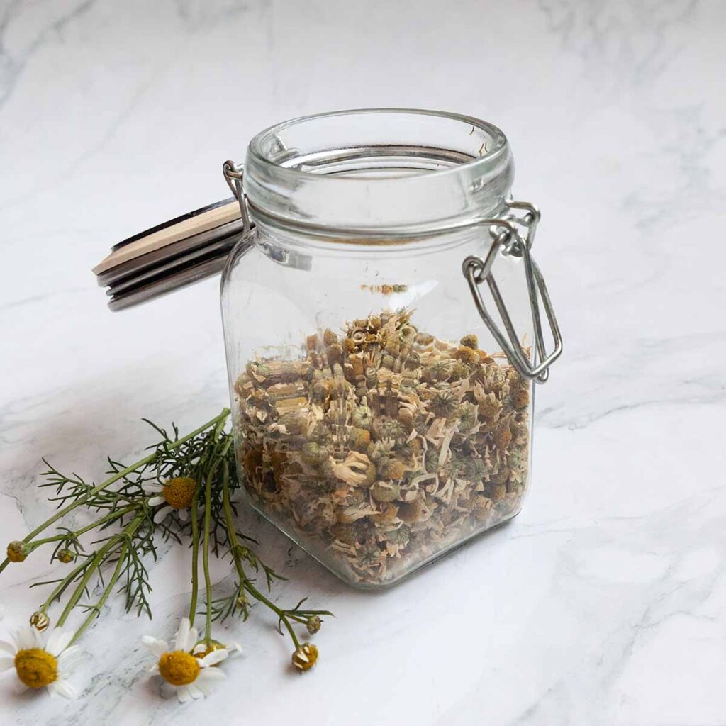A jar of dried chamomile flowers.