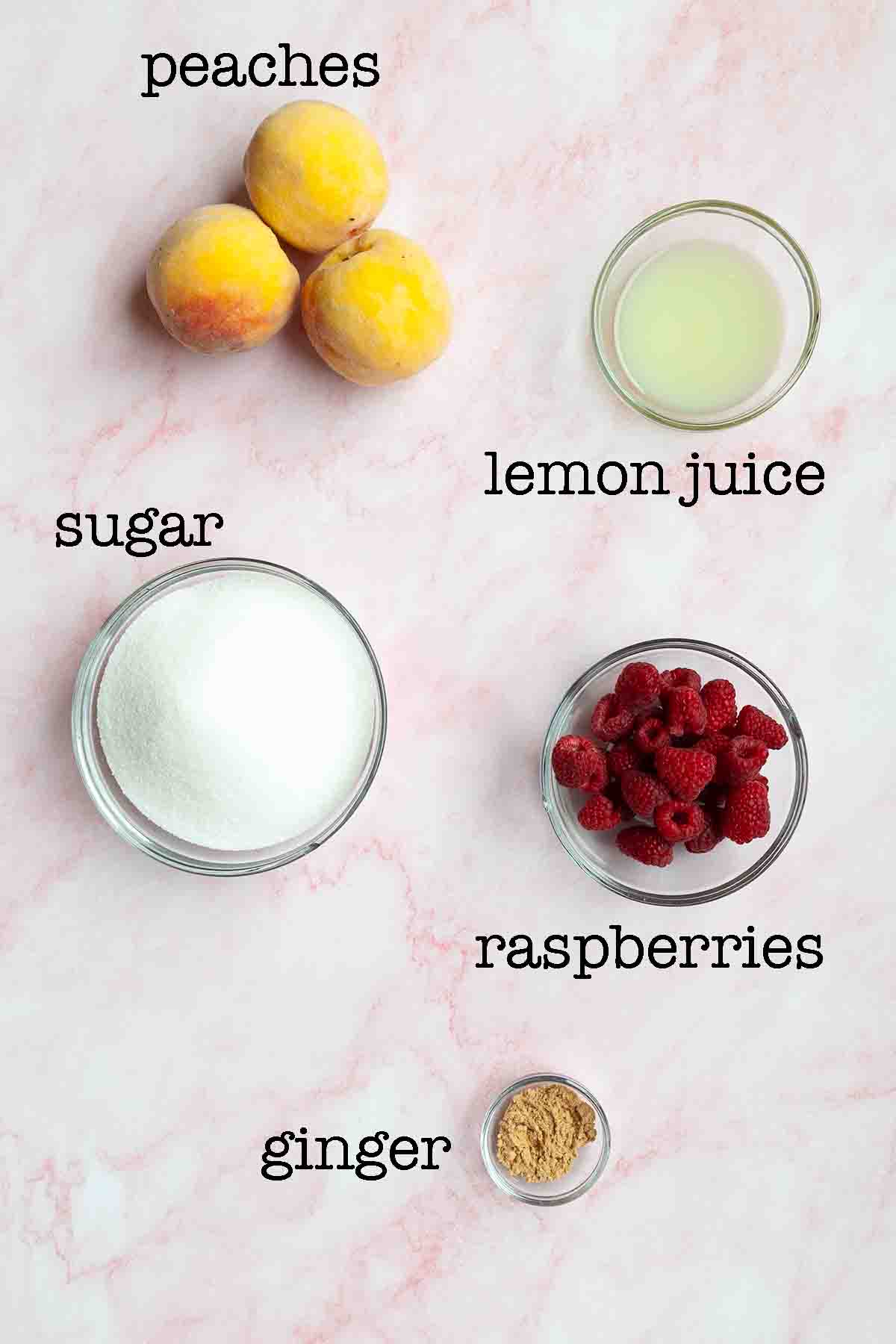 Ingredients for peach raspberry jam--peaches, sugar, lemon juice, raspberries, and ginger.