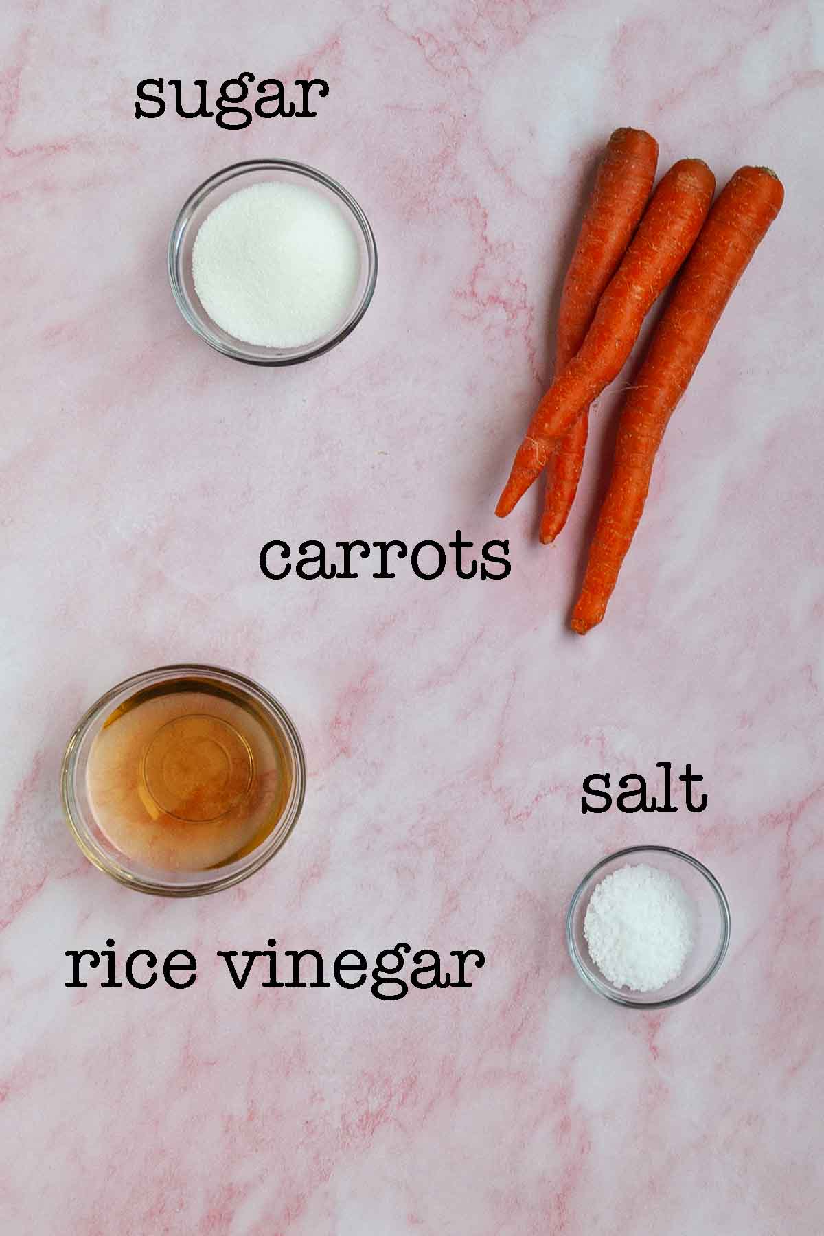 Ingredients for pickled shredded carrots--carrots, sugar, salt, and rice vinegar.