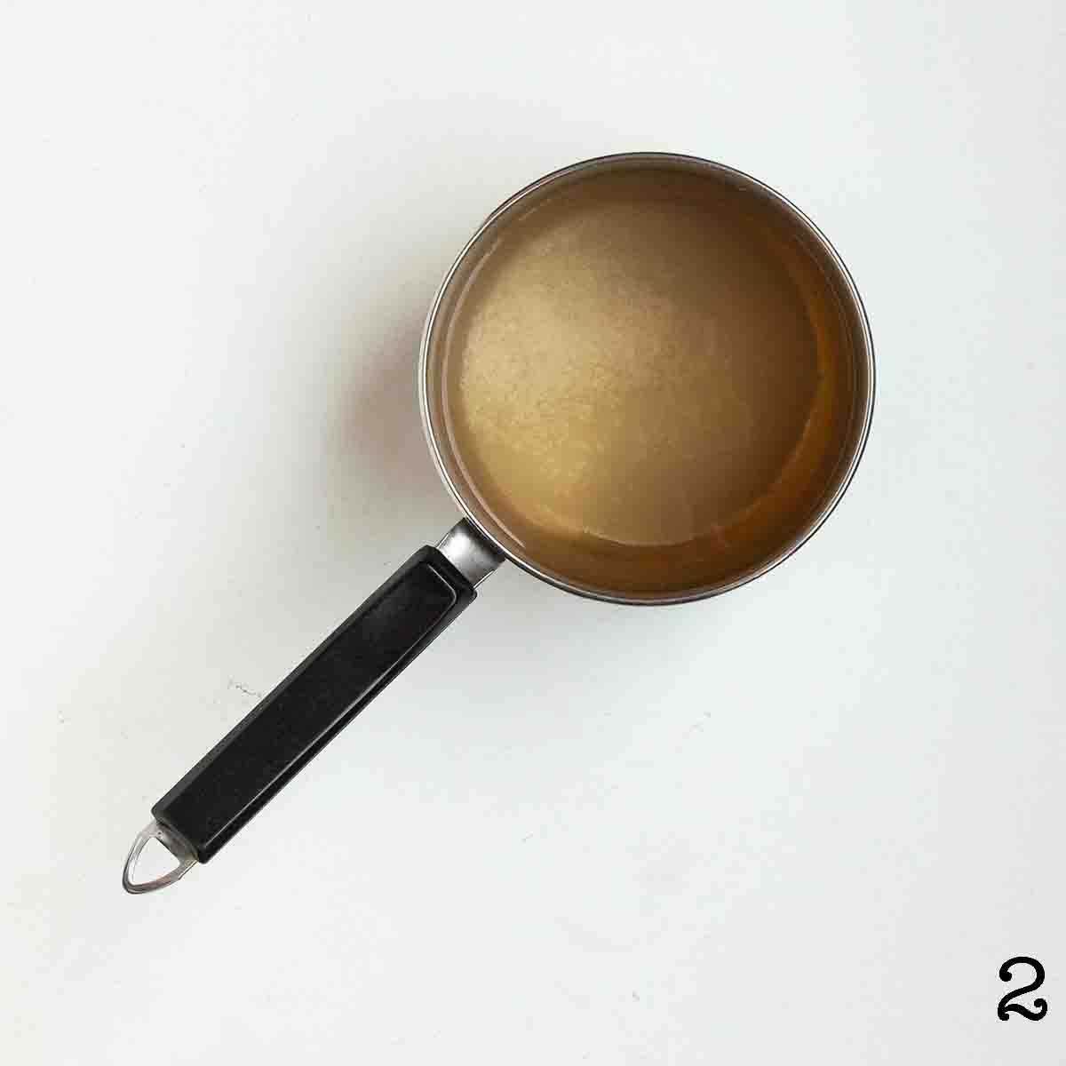 A pot with liquid, sugar, and salt inside.