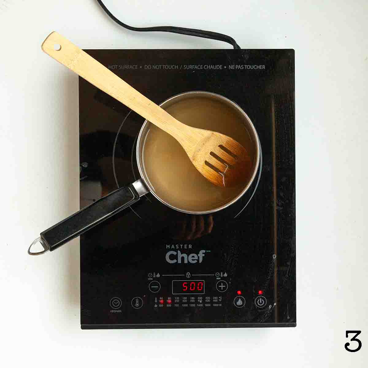 A pot on a portable burner with liquid inside.