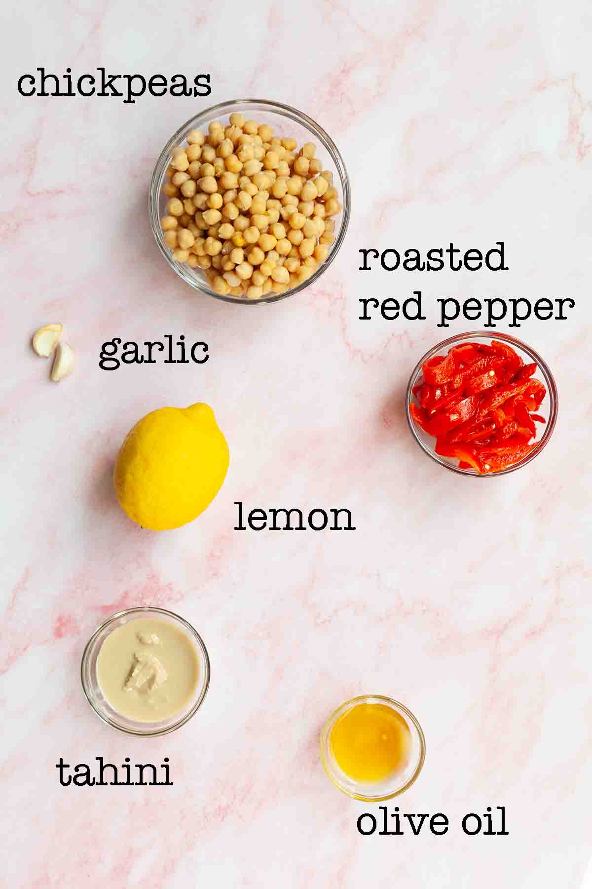 Ingredients for roasted red pepper hummus--chickpeas, garlic, roasted red peppers, lemon, tahini, and olive oil.