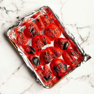 Roasted red peppers on a baking sheet.