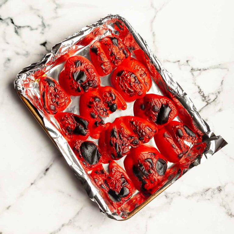 Roasted red peppers on a baking sheet.