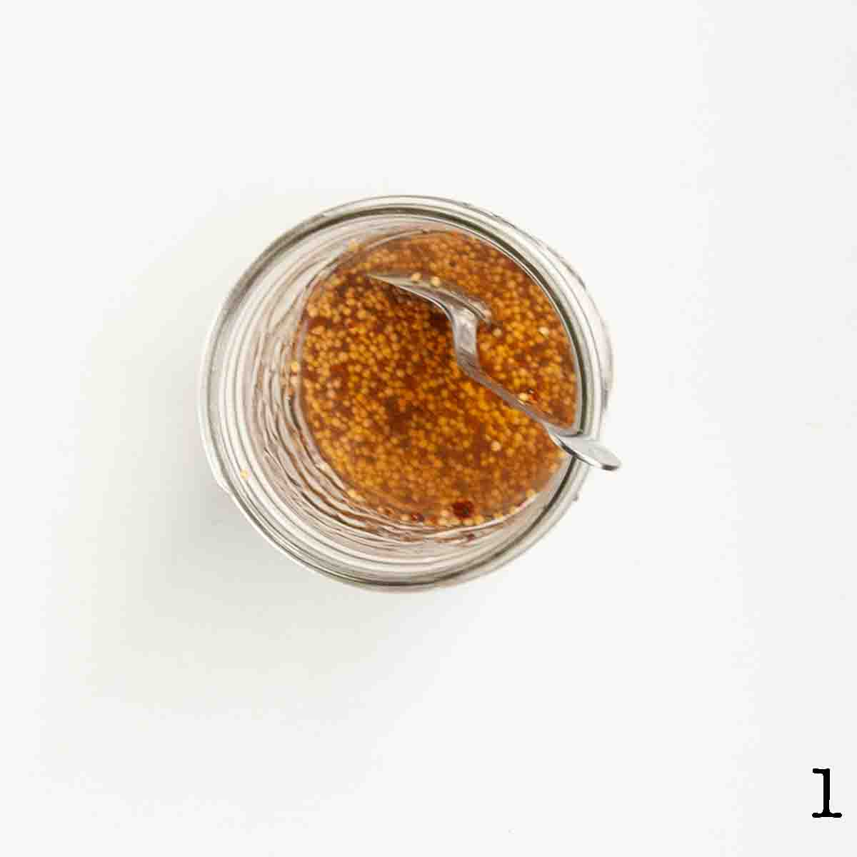 A jar of mustard seeds soaking in water.